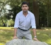 Rishi Tandulwadkar founder of Wiggles India stands outdoors with hands on a large rock